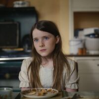 Titel: An Cailín Ciúin | The Quiet Girl | Das stille Mädchen Die 11 Jährige Cáit (Catherine Clinch) lebt gemeinsam mit ihren 4 Geschwistern in ärmeren Verhältnissen. Die Mutter ist hochschwanger und schafft es gerade so das nötigste vom Haushalt am laufen zu halten und ihr Vater zieht sich oftmals zurück, gönnt sich gern noch ein Bierchen in einer Bar und wenn er zuhause ist, lässt er eher nur abfällige Anmerkungen ggü. seinen Kindern über seine Lippen wandern. Es ist kaum verwunderlich, dass sich Cáit sehr stillschweigend in ihre eigene Welt zurückzieht und sich nach mehr Ruhe sehnt. In der Schule tut sie sich auch entsprechend schwer und wird von anderen Schülern als äußerst merkwürdig deklariert. Eines Abends belauscht Cáit ihre Eltern und bekommt mit, das ihr Vater sie gerne woanders unterbringen möchte. Kurz darauf liest dann ihre Mutter einen handgeschriebenen Brief und so kommt Cáit ohne weitere Informationen oder einen nennenswerten [&hellip;]